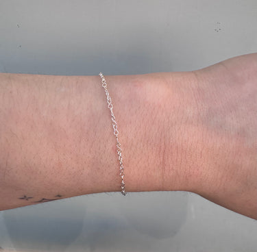 Silver chain with hourglass shaped links on a wrist