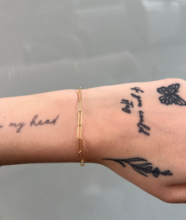 long paperclip link gold chain on wrist