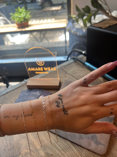 a model's hand with multiple bracelets on her wrist