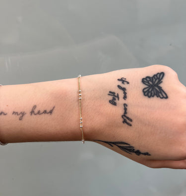gold chain with silver triple beads on wrist