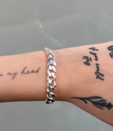 Thick silver curb chain on wrist