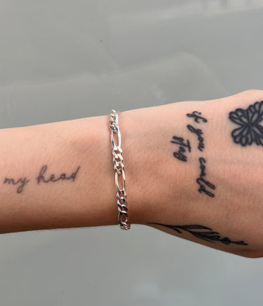 chunky figaro style silver chain on wrist
