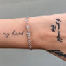 Silver chain with round clear stones on wrist
