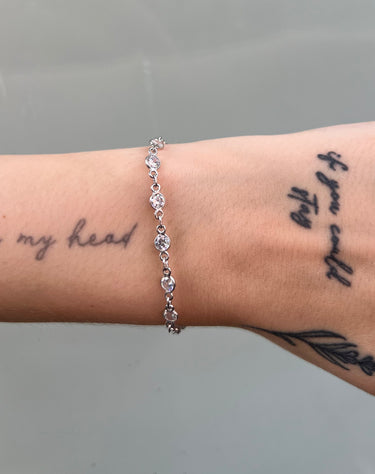 Silver chain with round clear stones on wrist