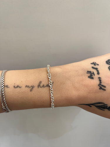 Twisted link silver chain on a wrist
