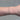Silver chain with gold beads on a person's wrist on grey background