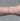 Silver chain with gold beads on a person's wrist on grey background