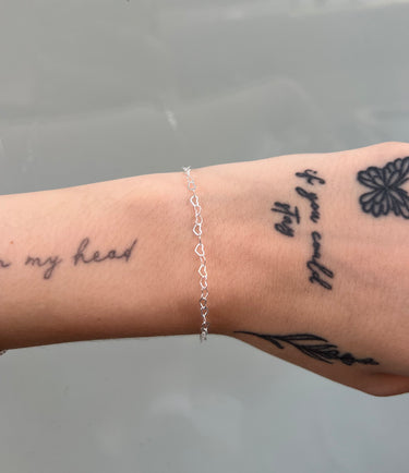 Silver chain with heart shaped links on wrist