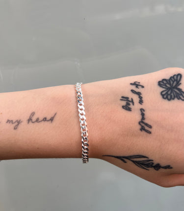 Medium thick silver curb chain on wrist