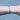 Black chain with silver beads on a person's wrist on grey background