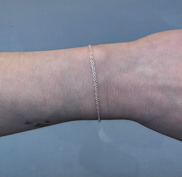 silver chain with pretzel shaped links on a wrist