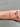 Bracelet on a wrist with tattoos against a gray background