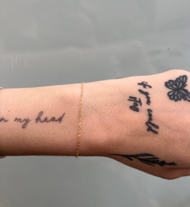 gold thin cable chain on wrist