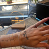 a model's hand with multiple bracelets on her wrist