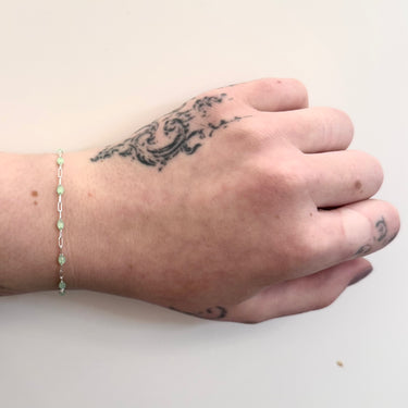 Silver chain with green enamel on a wrist