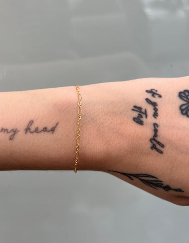 figaro style cable chain in gold on a wrist