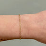 gold chain with diamond shaped links on a wrist