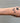 gold chain with hourglass shaped links on a wrist