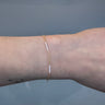 Gold cable chain with white enamel on a wrist