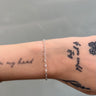 The sterling silver oval linked chain on a model's wrist