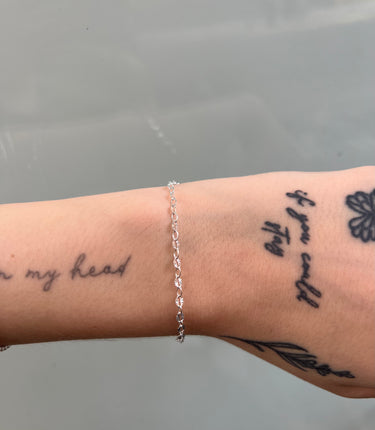 The sterling silver oval linked chain on a model's wrist