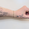 silver and gold filled figaro chain on a wrist