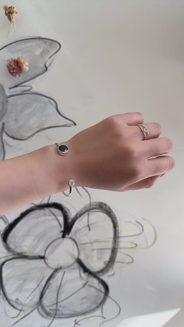 video model shot of silver black spinel and moonstone handcuff bracelet