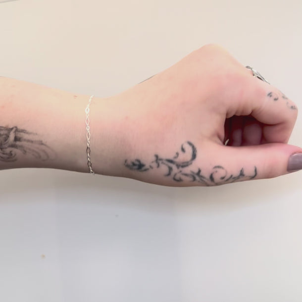 Silver diamond link chain on a wrist
