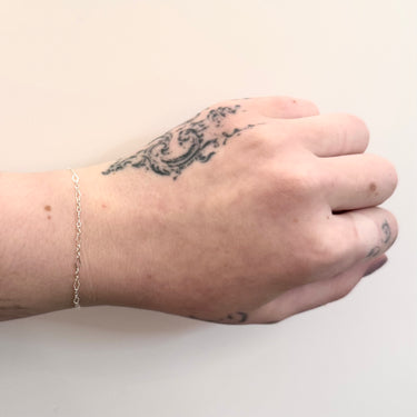 Silver diamond link chain on a wrist